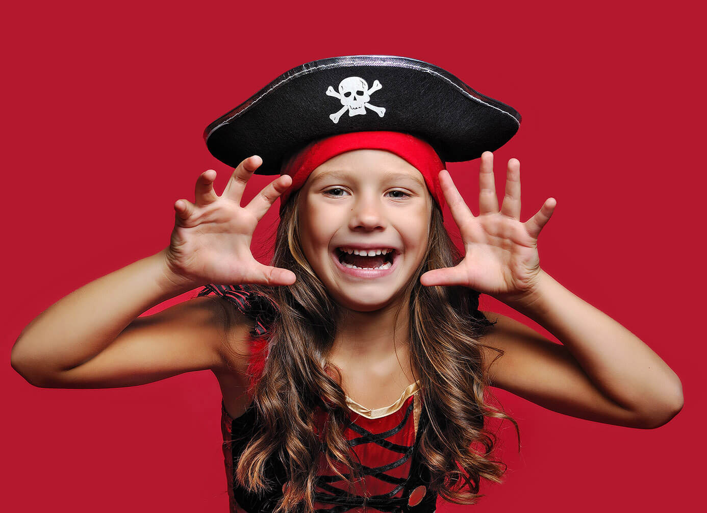 Ein Mädchen im Piratenoutfit, das vor zu hohen Preisen für Zahnschienen warnt